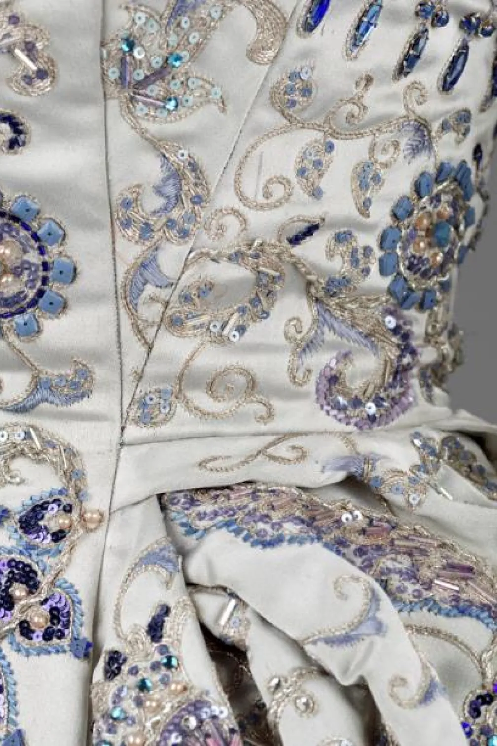 Photo of a white gown with blue jewelled detailing