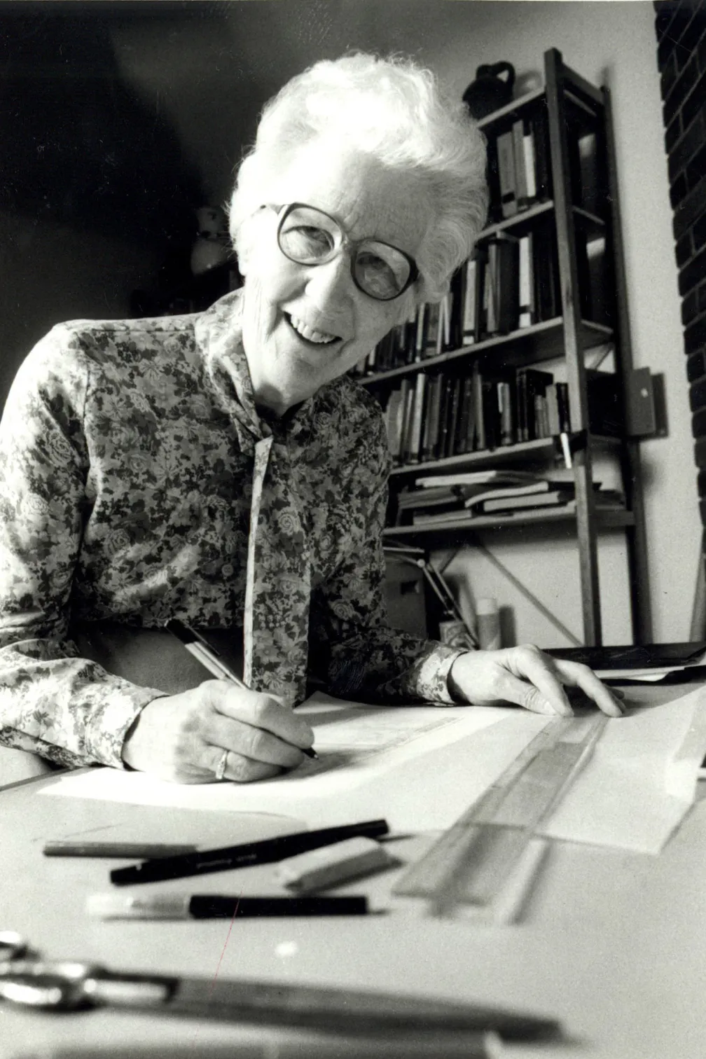 Black and white photo of Dorothy Burnham at a drafting table
