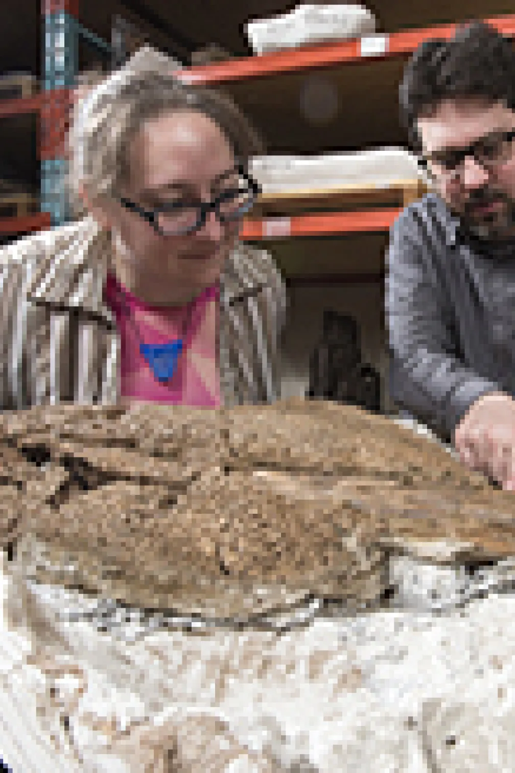 Photo of two people with a fossil
