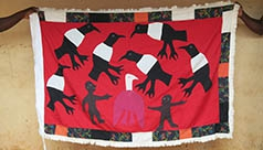 People holding up a handmade flag depicting birds.
