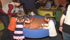 Volunteers help kids dig for dinosaur bones in the Hands-On Galleries at the ROM