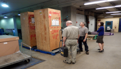 Inside the shipping room, inspecting a wooden crate