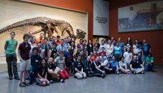 A group photo of all 2014 ROM Game Jam participants in front of a dinosaur skeleton