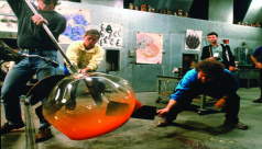 Three men in a glass-blowing workshop