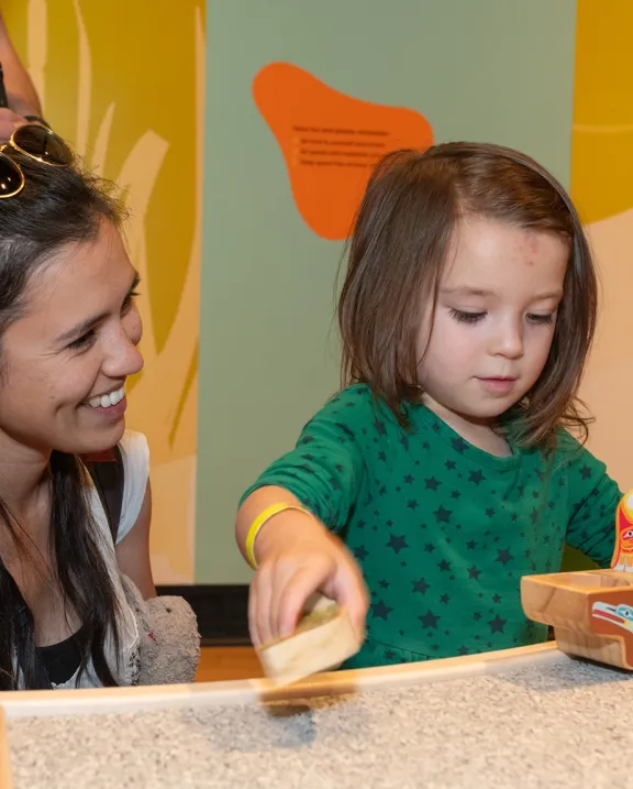 Child enjoying ROM Kids Junior program with parent watching