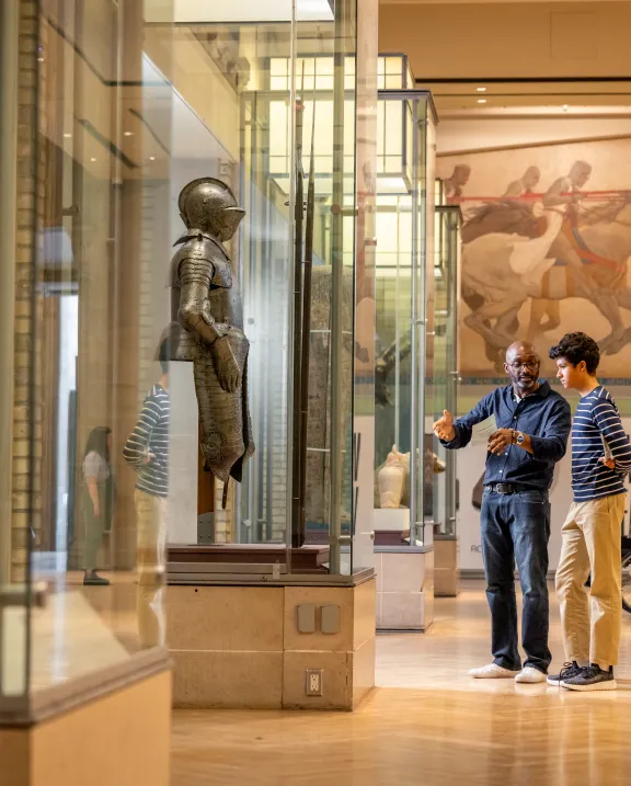 Two people looking and discussing a case of a knife in Currelly gallery