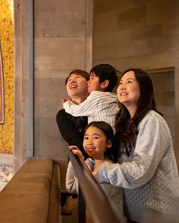 A family looking up at ROM's ceiling.