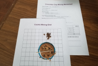 Chocolate chip cookie on grid paper, toothpick, and paperclip on the paper, beside the Chocolate Chip Mining Worksheet