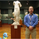 photo d'une homme et d'une tortue en dessin animé devant une statue d'Aphrodite