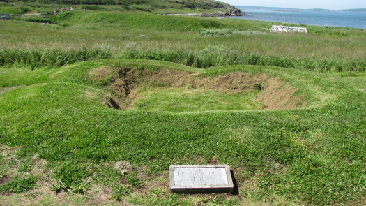 a field with a stone marker near a depression