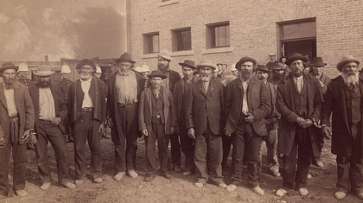 a sepia-toned photo of male prisoners standing in a line