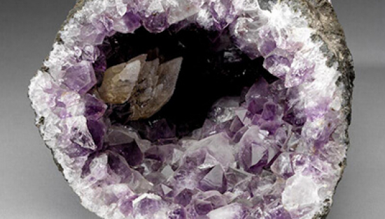 A geode that has been split in half, showing the amethyst crystals growing inside.