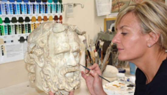 Laura Lipcei painting a Greek statue.
