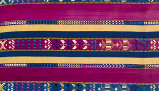 A piece of textile with broad fuchsia stripes and more narrow cream and teal stripes. Some of the strips have geometric motifs on them. 