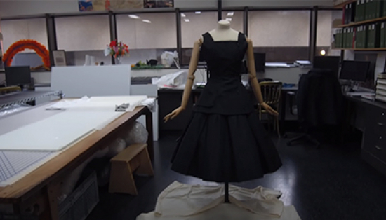 Screenshot of a video of a black sleeveless dress on a mannequin in a research lab.