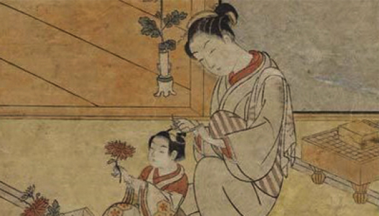 A Japanese print of a young woman dressing a boy’s hair, with a view from the room onto a garden. 