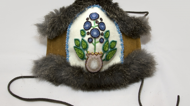 A mask created with beeds in the shape of a blue berry