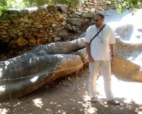 Man with glasses standing in front of nature.