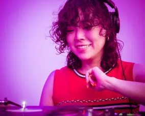 DJ Sakiko Nagai posing in front her equipment.