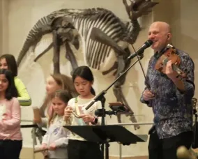 Chris McKhool performing with children at ROM.