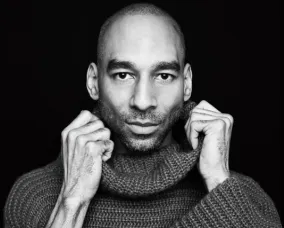 Headshot of a man wearing a dark turtleneck shirt.