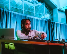 DJ Paul Chin performing behind his equipment.