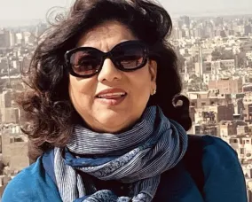 A woman with dark hair wearing sunglasses.