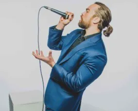 Scott Jackson in a blue suit singing.