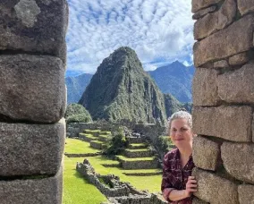 A woman with light hair visiting Machu Picchu in Peru.