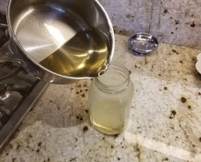 Mixture being poured into a mason jar.