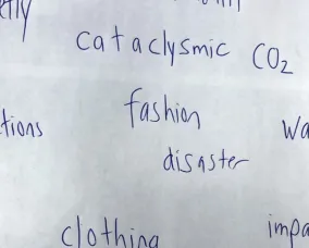 Paper with the written words pretty, cataclysmic, CO2, actions, fashion, disaster, warning, clothing, impacts