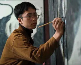 Japanese artist Yuta Niwa working on a painting. Photo credit Art News Japan.