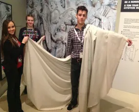 Les jeunes femmes tiennent le tissu du côté blanc du jeune homme. Le tissu passe sous le bras du jeune homme.