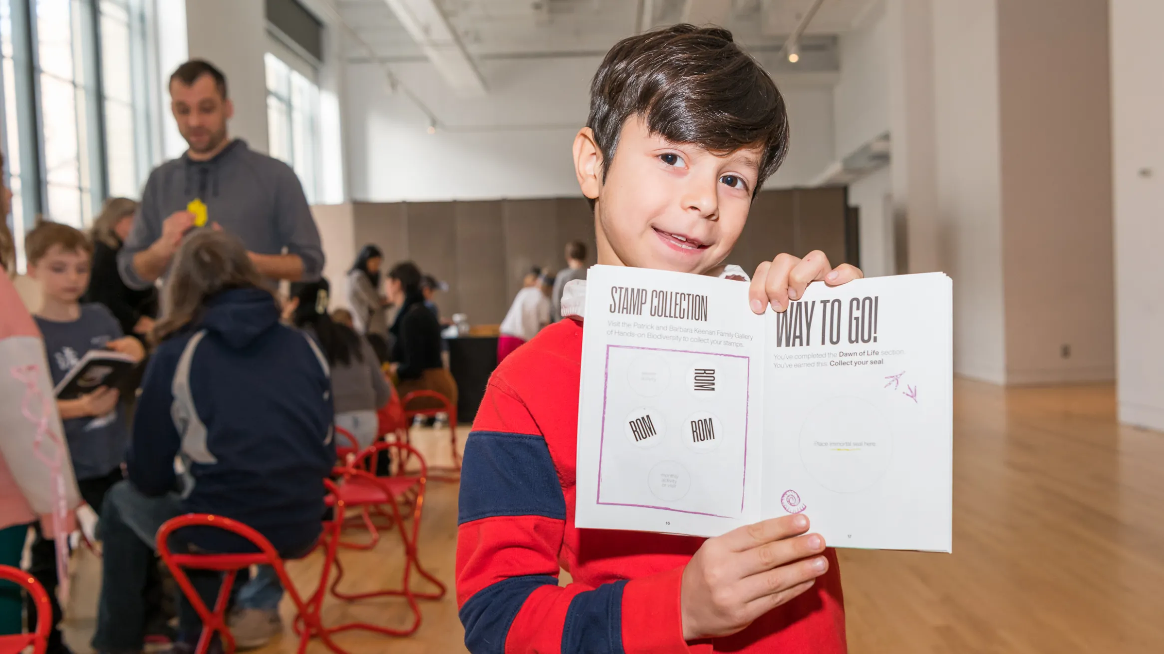 A kid holding up a book.