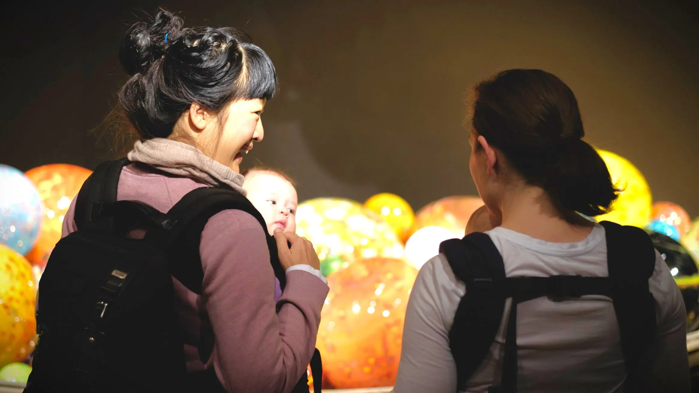 Two mothers carry with their baby in a carrier bag at ROM 