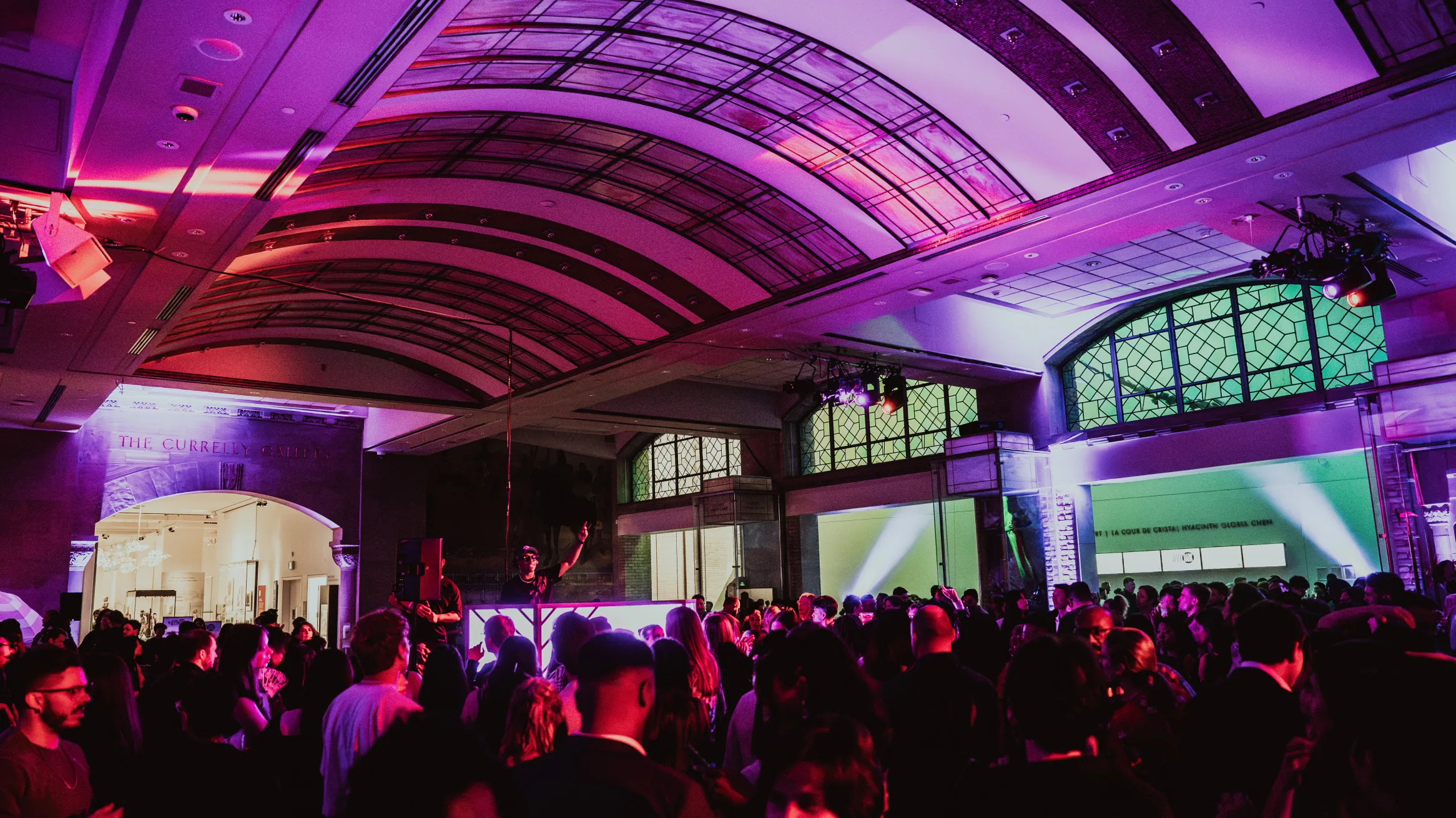 A DJ performing for a crowd at Royal Ontario Museum in the Currelly Gallery.