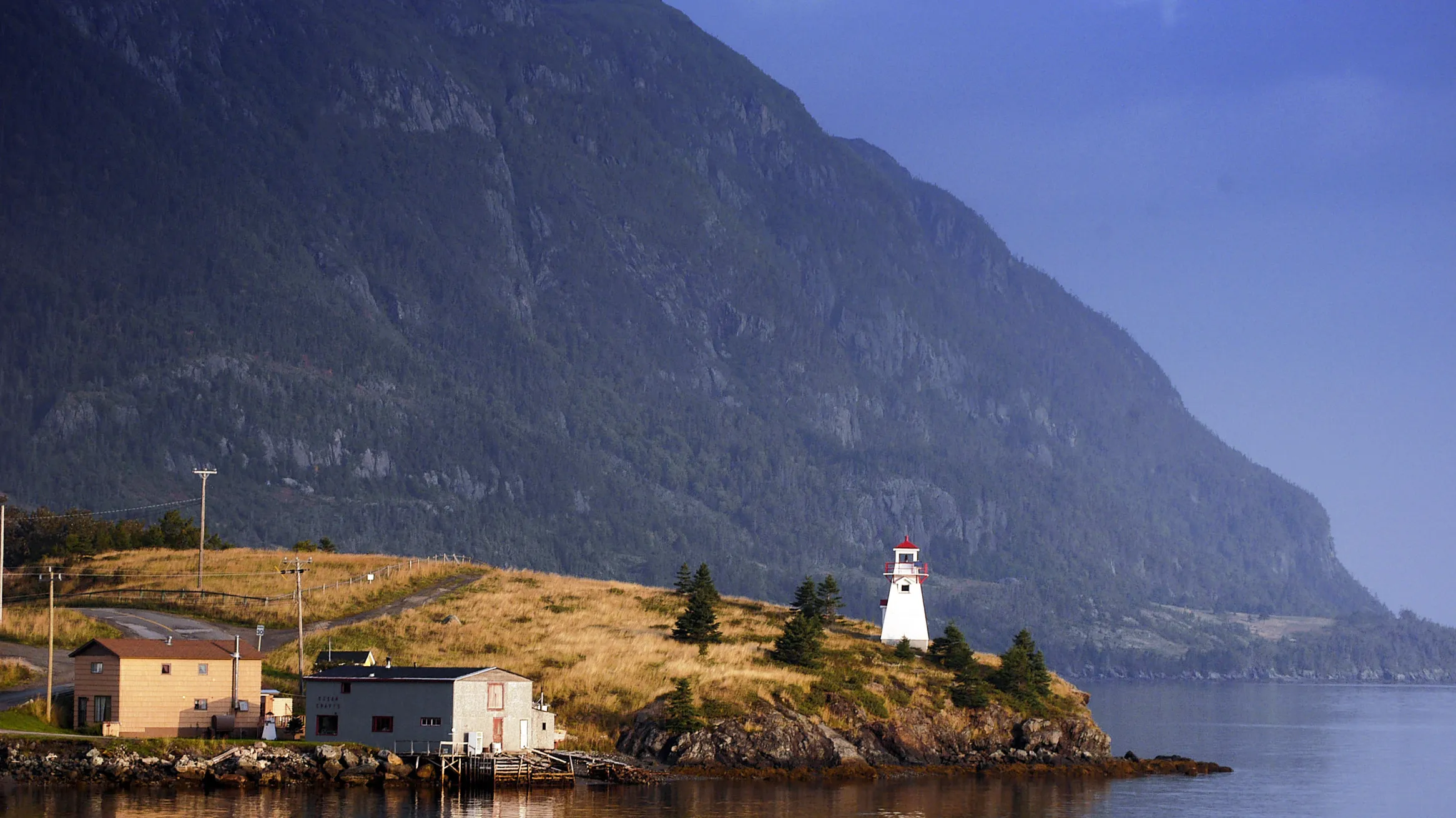 A lighthouse with a mountain in the background.